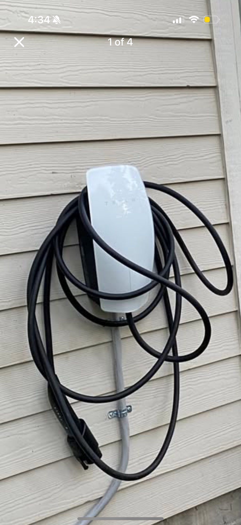 Outdoor Tesla charger on house siding